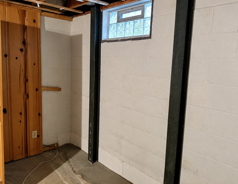 Steel I-beams installed to stabilize a block foundation wall
