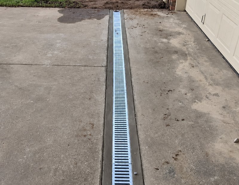 Linear trench drain installed across a garage driveway